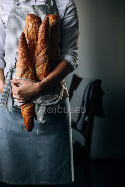 Woman standing with baguettes — Stock Photo