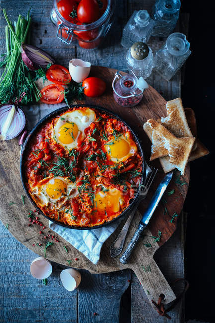 Fried eggs with herbs in frying pen — Stock Photo