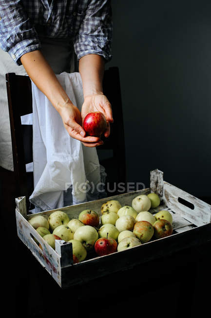 Frau nimmt roten Apfel — Stockfoto