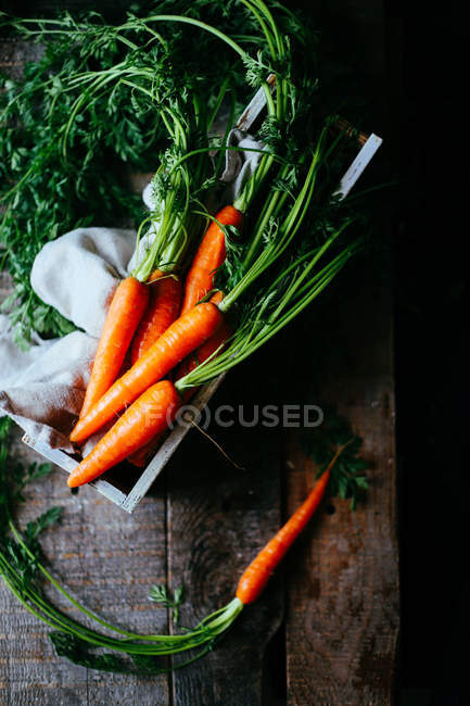 Raw carrots in wooden box — Stock Photo