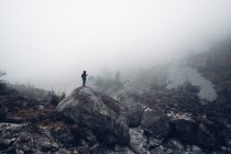 Людина стоїть на вершині великої скелі — стокове фото