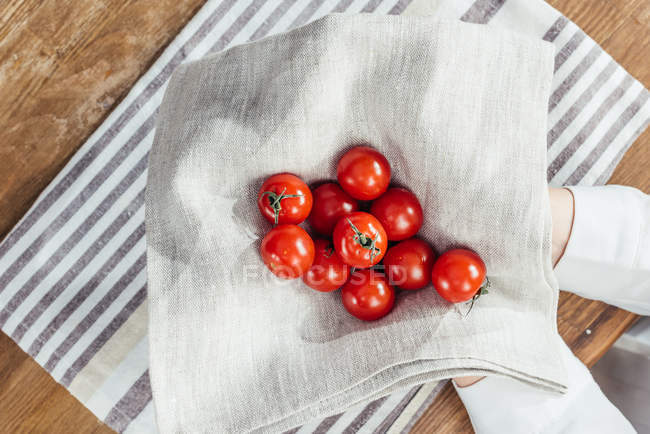 Tomates cereja em mãos — Fotografia de Stock