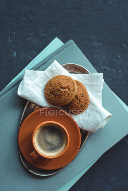 Café con galletas en servilleta de mesa y libros - foto de stock