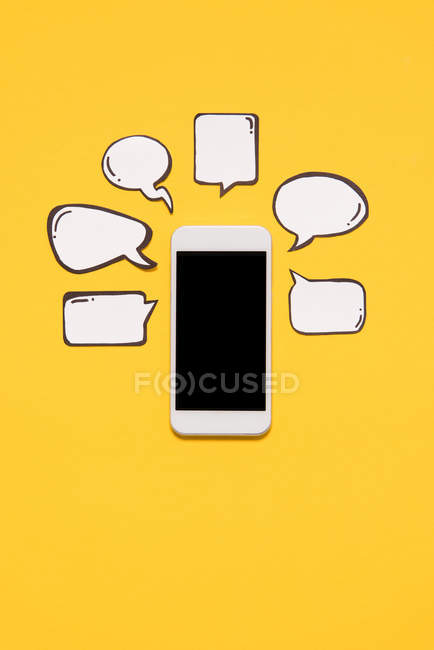 Smartphone et bulles de parole vierges — Photo de stock