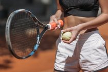 Colpo ritagliato di atletica giovane donna con racchetta da tennis e palla — Foto stock