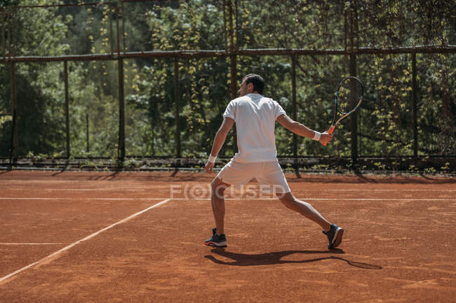 Young tennis player ready for serve on outdoors court — Stock Photo