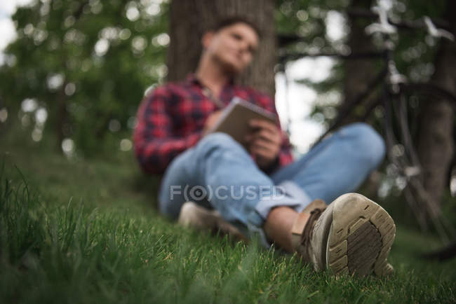 Jeune homme prenant des notes dans un carnet — Photo de stock