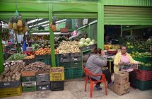 Женщины сидят на овощном и фруктовом рынке — стоковое фото
