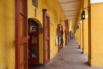 Reihe kleiner Geschäfte in gelbem Gebäude — Stockfoto