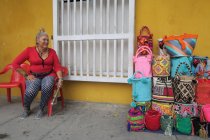 Senhora sentado e vendendo sacos artesanais — Fotografia de Stock