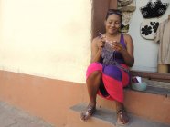 Женщина полирует ногти и сидит на ступеньках — стоковое фото