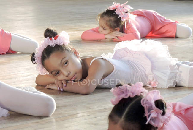 Chicas en la práctica de ballet y tumbadas en el suelo - foto de stock
