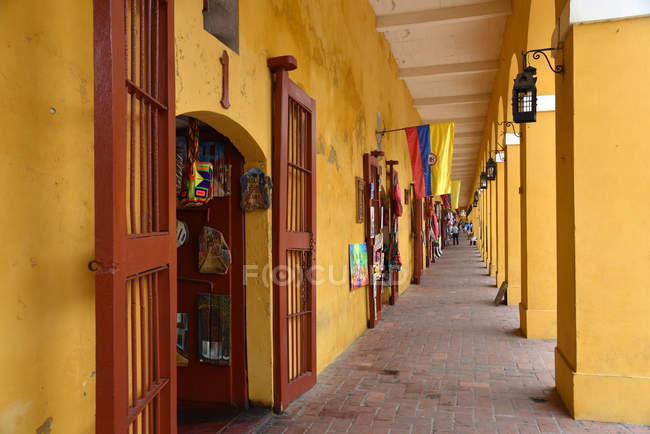 Linha de pequenas lojas no edifício amarelo — Fotografia de Stock