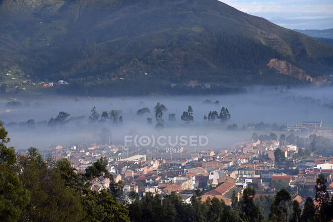 Утренний туман над зданиями — стоковое фото