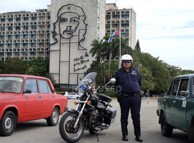 Oficial de policía de pie cerca de motocicleta - foto de stock