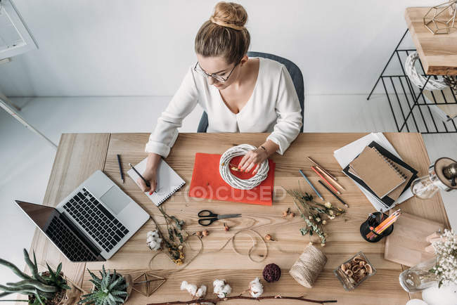 Fiorista con fiori sul posto di lavoro — Foto stock