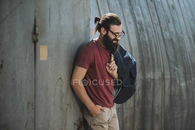 Uomo appoggiato indietro sul vecchio hangar — Foto stock