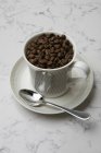 Coffee beans in coffee cup — Stock Photo
