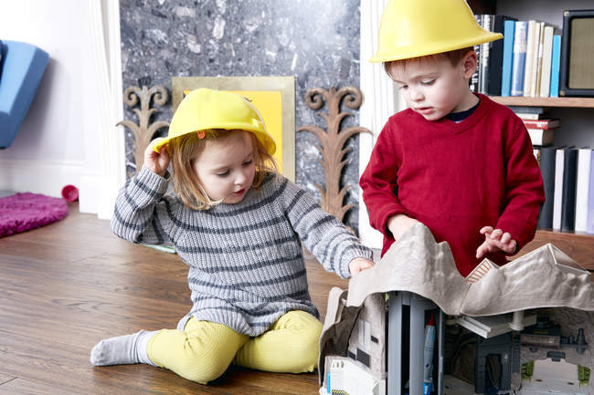 Hermano y hermana con cascos amarillos - foto de stock