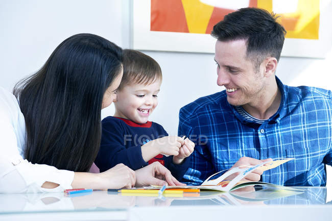 Padres e hijo jugando con juguetes - foto de stock