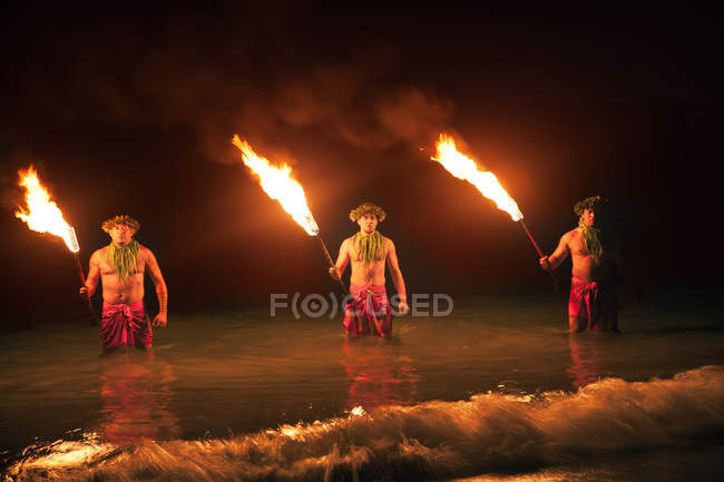 Bailarines de fuego en las islas hawaianas por la noche - foto de stock