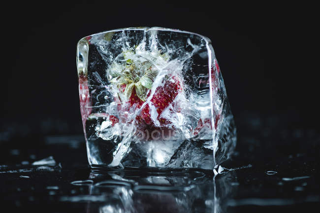 Strawberry frozen in ice cube — Stock Photo