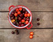 Pentola di smalto con ciliegie fresche e pulite — Foto stock