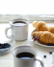 Duas xícaras de chá, mirtilos e croissants — Fotografia de Stock