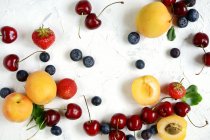 Pfirsiche, Blaubeeren, Kirschen und Erdbeeren auf dem Tisch — Stockfoto