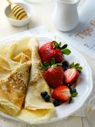 Thin pancakes with strawberries and blueberries — Stock Photo