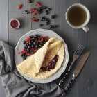 Dünne Pfannkuchen mit roten und schwarzen Johannisbeeren — Stockfoto