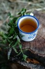 Cup of tea on log — Stock Photo