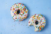 Dois donuts com cobertura na superfície azul — Fotografia de Stock