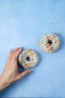 Weibliche Hand streckt sich zu Donuts — Stockfoto