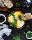 Fried eggs with bread and green leaves — Stock Photo