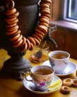 Closeup view of tea cups with samovar, lemon slices and cracknels — Stock Photo