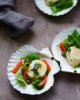 Veduta ravvicinata delle insalate con banana, pomodoro, piselli ed erbe tagliate a fette sulle conchiglie — Foto stock
