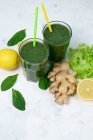 Gläser Spinat mit Zitrone und Ingwer grüner Smoothie auf weißer Oberfläche mit Zutaten — Stockfoto
