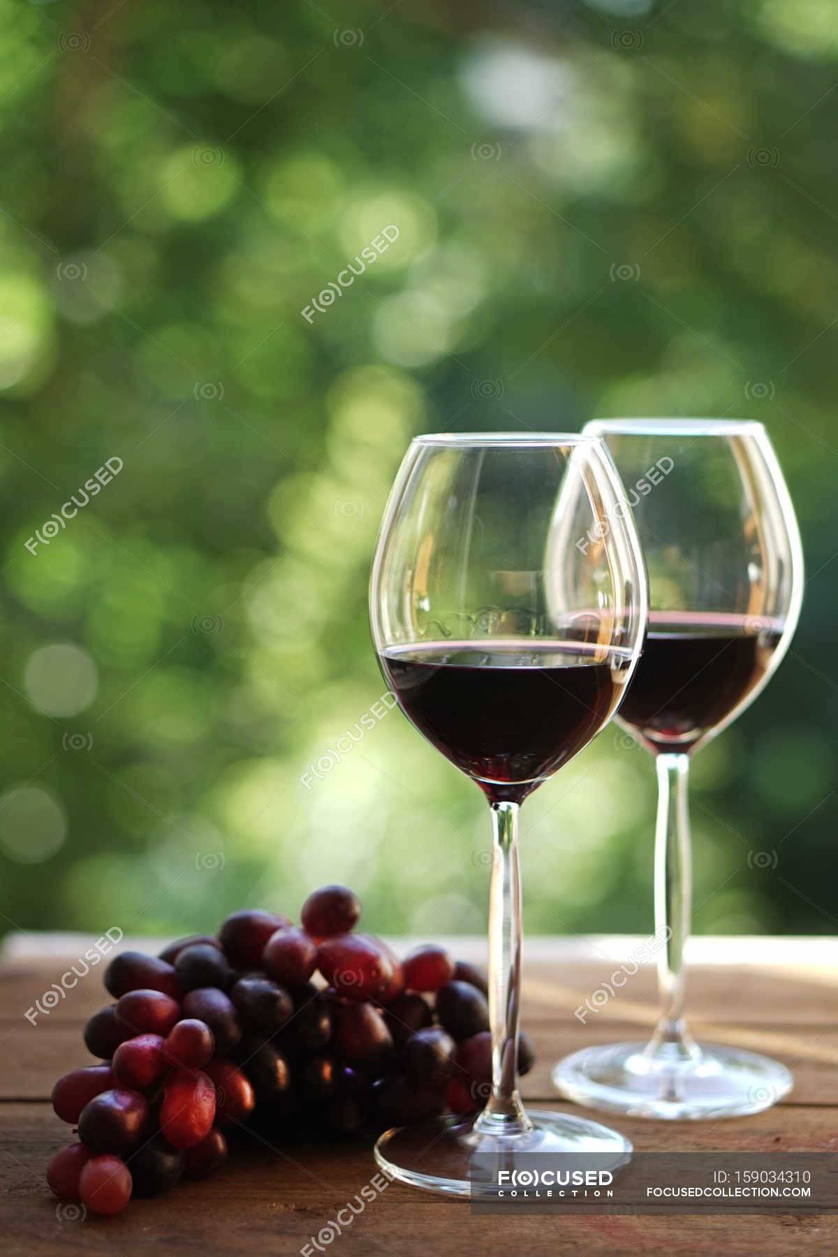 two-glasses-of-red-wine-and-grapes-wooden-choice-stock-photo