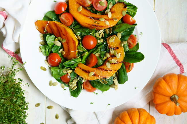 Salat mit gegrilltem Kürbis, Spinat und Tomaten — Stockfoto