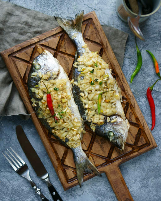 Dos carpas de pescado al horno con cebolla - foto de stock