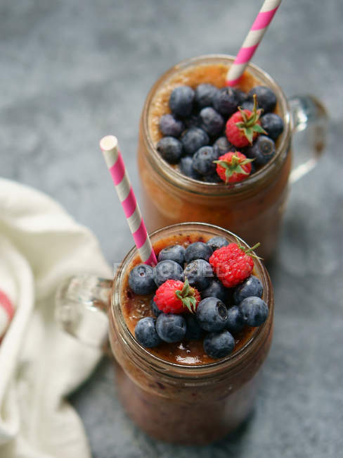 Glasses of chocolate, blueberry and raspberry smoothie — Stock Photo