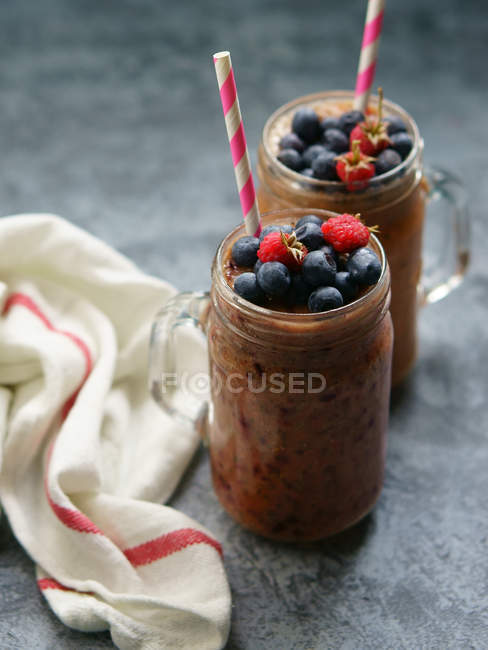Glasses of chocolate, blueberry and raspberry smoothie — Stock Photo