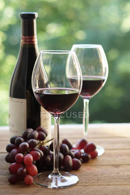 Two glasses of red wine and grapes — Stock Photo
