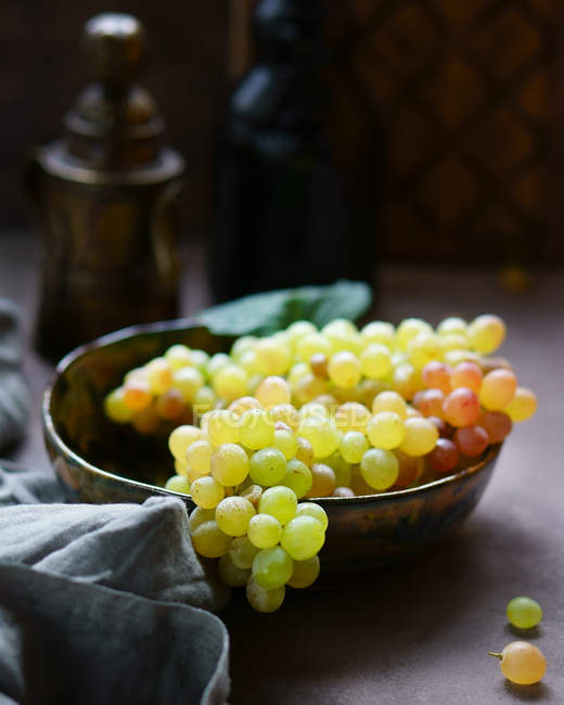 Uvas frescas em tigela na mesa — Fotografia de Stock