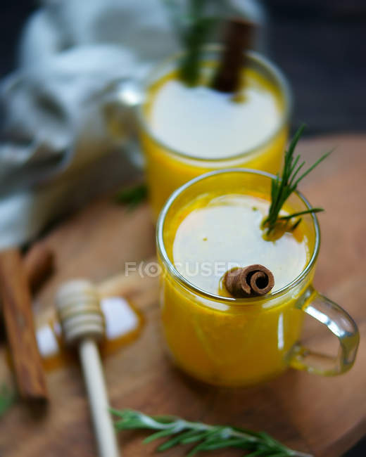 Cups with orange juice and herbs — Stock Photo