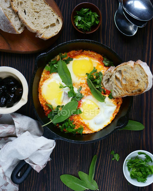 Fried eggs with bread and green leaves — Stock Photo