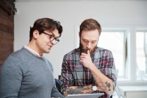 Male designers looking at digital tablet — Stock Photo