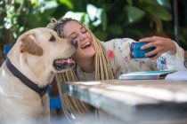 Mujer joven tomando selfie con perro mascota - foto de stock