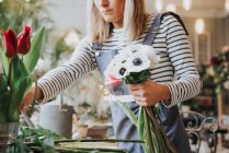 Флорист готує букет у квітковому магазині — стокове фото